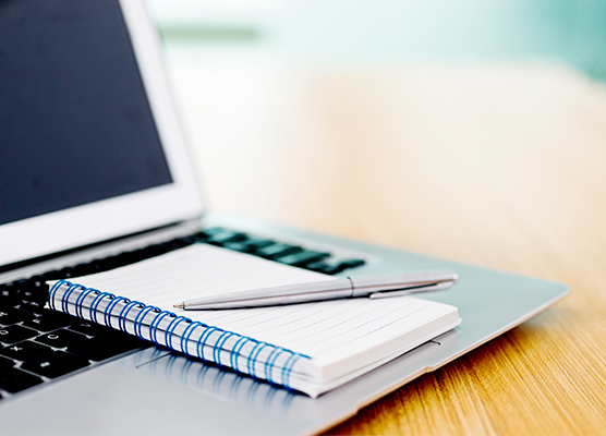 photo of a laptop and notebook