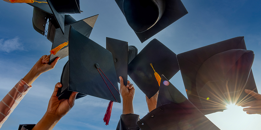 photo of graduation caps in the air